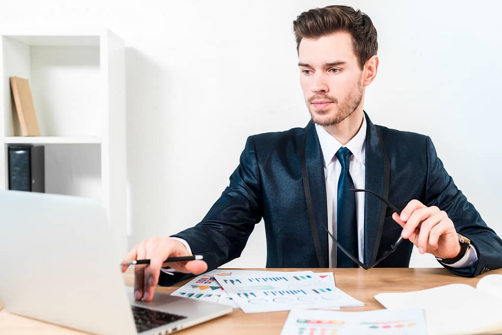 young-confident-businessman-using-laptop-workplace-office